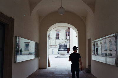 Rear view of man walking in corridor of building