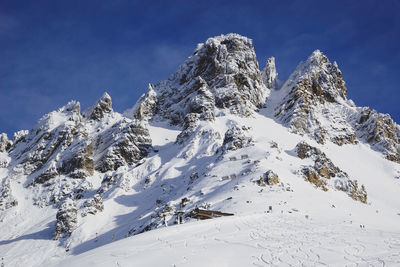 Snow covered mountain against blue sky