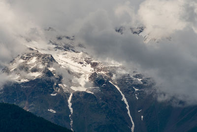 Snow capped peaks of cloud shrouded rocky mountains