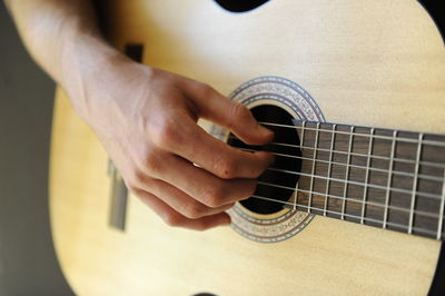 Midsection of man playing guitar