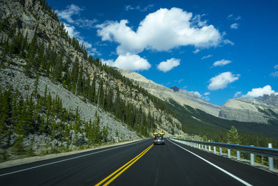 Road by mountain against sky