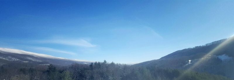 Scenic view of mountains against blue sky