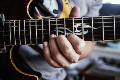 Midsection of man playing guitar