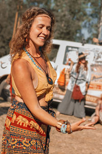 Portrait of young woman standing against trees