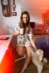 Portrait of young woman sitting on table