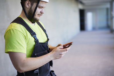 Worker using cell phone at building site