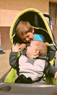 Happy siblings in baby stroller