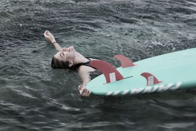 High angle view of smiling woman swimming in sea