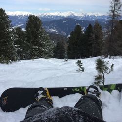 Low section of person with snowboard on snow covered field