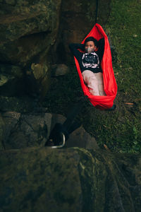 Rear view of boy sitting on rock