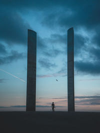 Silhouette man walking against sky during sunset