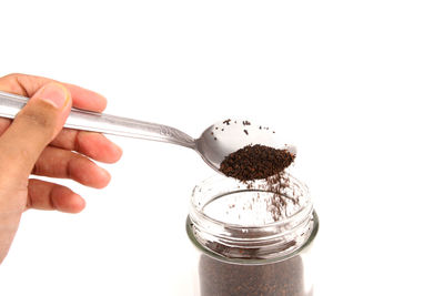Close-up of hand holding wineglass against white background