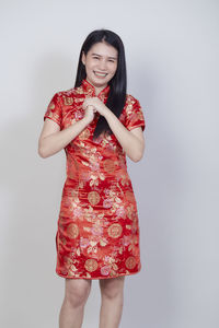 Portrait of smiling young woman against white background