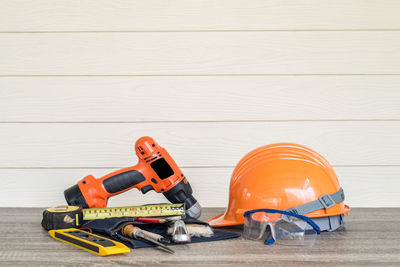 Work tools on wooden table against wall