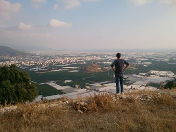 Man looking at cityscape against sky