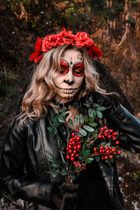 Closeup portrait of calavera catrina. young woman with sugar skull makeup and red flowers. dia