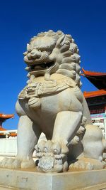 Low angle view of statue against blue sky