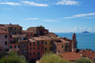 Buildings by sea against sky in city, tellaro