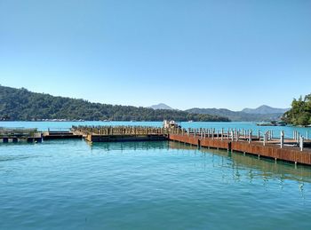 Jetty over sun moon lake against clear sky