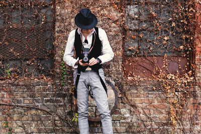 Retro-styled man with vintage medium format photo camera outdoors.