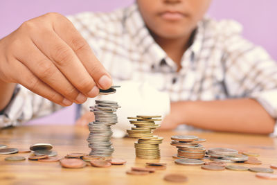 Boy stacking coins at table