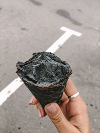 Close-up of person holding ice cream cone on street