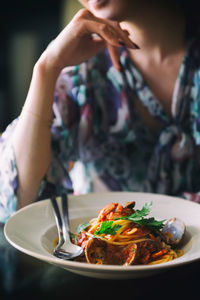 Midsection of woman with meal at table