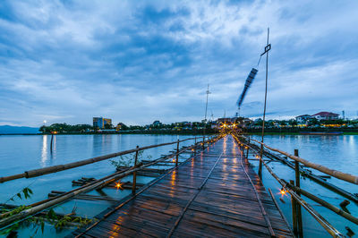 Pier over lake against sky at dusk