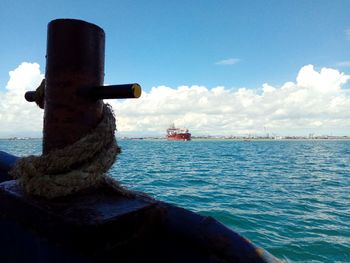 Close-up of ship sailing in sea against sky