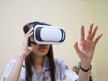 Woman gesturing while using virtual reality simulator