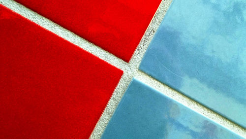 Close-up of blue and red tiles on wall
