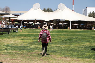 Rear view of people walking on field