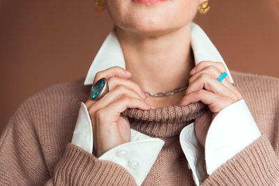 Cropped picture fashion woman in brown oversize sweater with stylish accessories