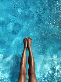 Low section of person legs in swimming pool