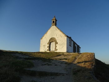 Low angle view of building against clear blue sky