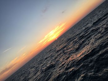 Scenic view of sea against dramatic sky during sunset