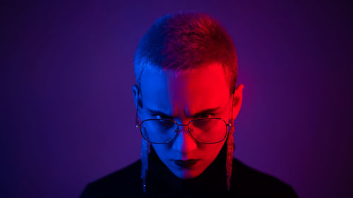 Portrait of angry woman against colored background