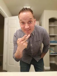 Portrait of smiling man standing at home