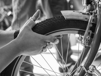 Cropped hand of man repairing bicycle