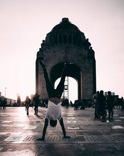 People at historical building against clear sky