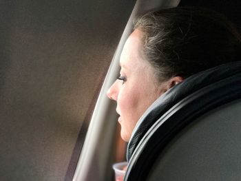 Close-up of mid adult woman sitting in airplane