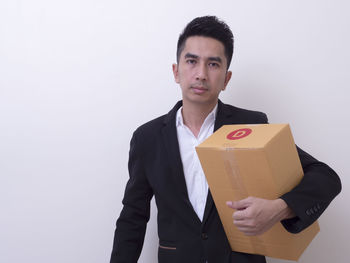 Portrait of young man standing against white background