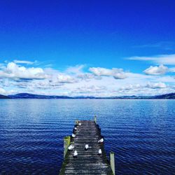 Scenic view of pier over sea against blue sky