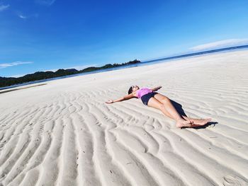 Woman on beach against blue sky