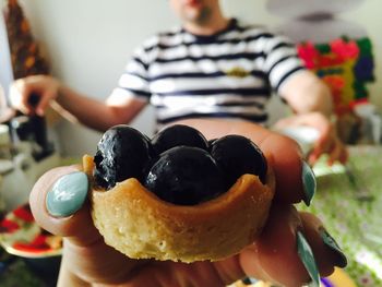 Cropped hand of woman holding dessert by man sitting at home