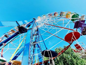 Low angle view of ferris wheel against blue sky