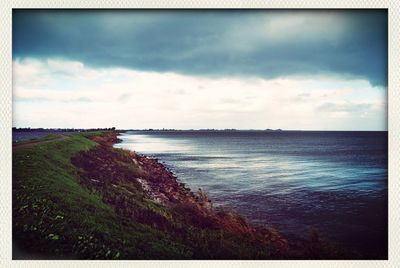 Scenic view of sea against cloudy sky