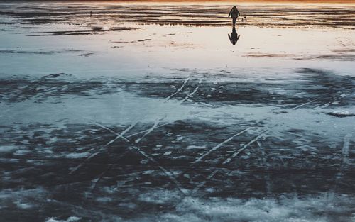 Reflection of frozen lake in puddle