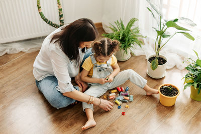 Mom and little daughter at home sculpt from plasticine and play together. the concept of preschool 