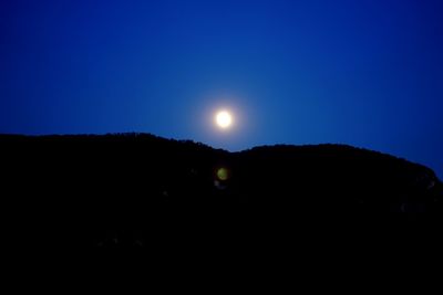 Silhouette landscape against sky at night